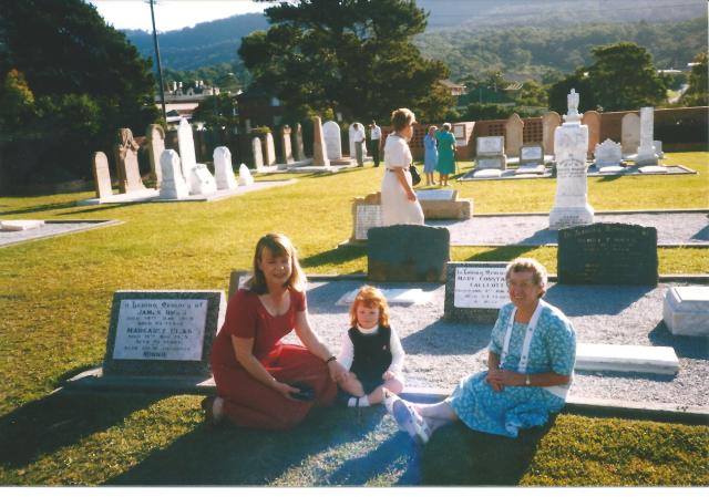 Kerrie Anne Christian with daughter Katrina Elise and Joan Adams, near the grave of James, Margaret and Minnie Hicks at St Augustine's Bulli
